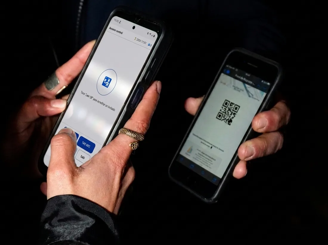 Lectura de un código QR con la cámara del teléfono en la puerta del evento